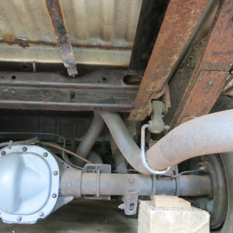 1995 Ford Bronco - Underside view of a vehicle's rear axle and exhaust system, with visible rust.