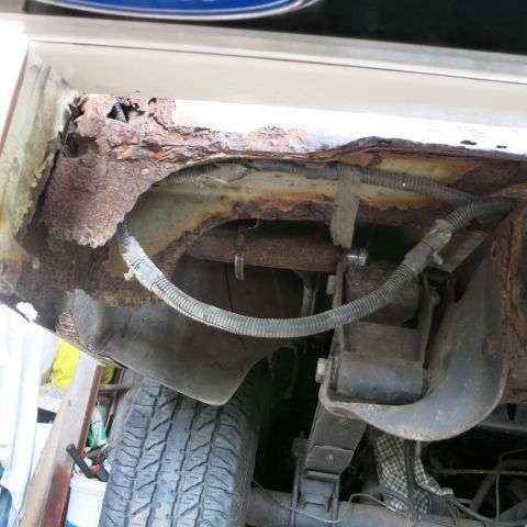 1995 Ford Bronco - Extensive rust damage is visible in the wheel well and on suspension components of this vehicle.