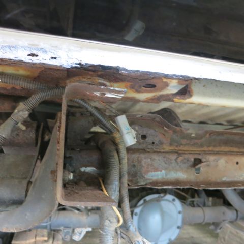 1995 Ford Bronco - Undercarriage view showing significant rust on the frame and suspension components.