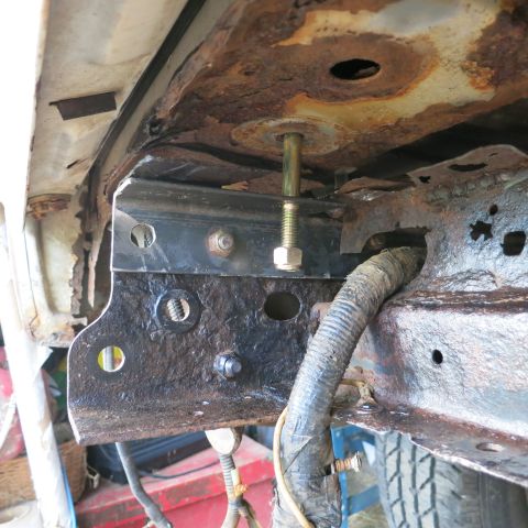 1995 Ford Bronco - This image shows a close-up of a vehicle's frame, highlighting rust and a newly installed bracket with a bolt and nut.