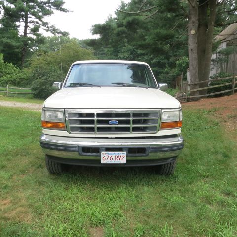 1995 Ford Bronco - Front view of a 1995 Ford Bronco parked outdoors on a grassy area.