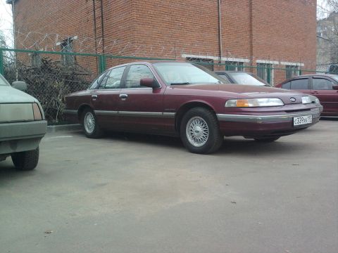 1992 Ford Crown Victoria - A maroon 1992 Ford Crown Victoria is seen parked next to another vehicle.