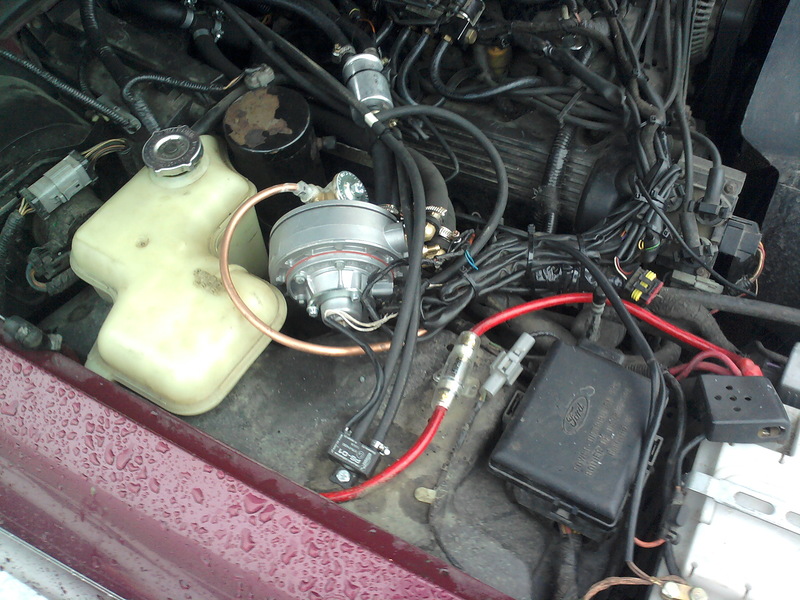 Engine bay with fuel pump and wiring, maroon fender visible