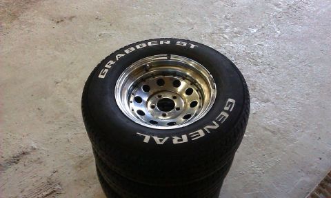 1992 Ford Crown Victoria - A stack of General Grabber ST tires with chrome rims sits on a concrete floor.