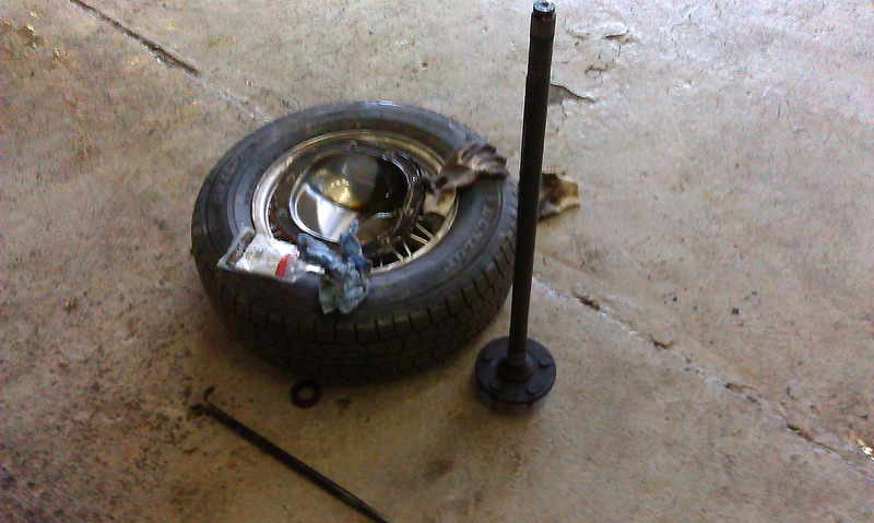 Axle shaft and spare tire on concrete floor