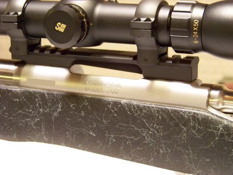 1995 Mercury Grand Marquis - Close-up of a Remington Model 700 rifle receiver and scope, showing the model name and serial number area.