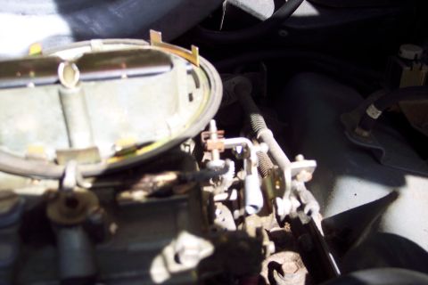 1991 Ford LTD Crown Victoria - Engine bay detail showing a carburetor and associated mechanical parts.