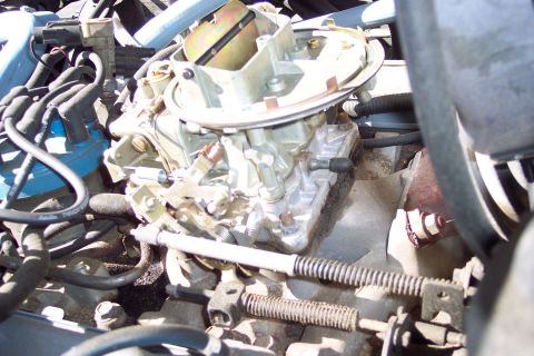 1991 Ford LTD Crown Victoria - Close-up view of a vehicle's carburetor and engine components.