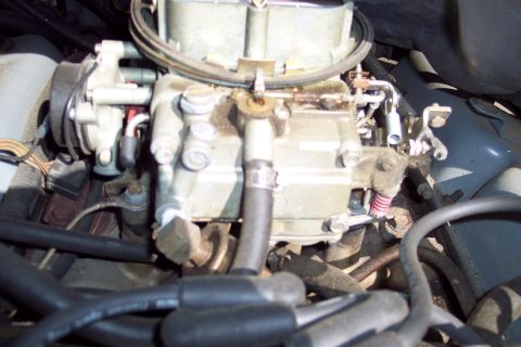1991 Ford LTD Crown Victoria - A detailed view of a vehicle's carburetor, showing its various components and connections.