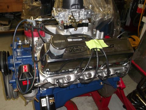 1970 Ford Mustang - A Ford V8 engine is shown, chrome valve covers and a Holley carburetor, mounted on an engine stand.