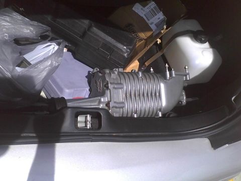 2003 Ford Crown Victoria - A supercharger and various items are stored in the trunk of a car.