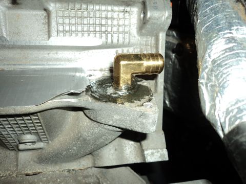 2004 Mercury Grand Marquis - Close-up of an engine component showing a brass fitting installed with sealant and tape.