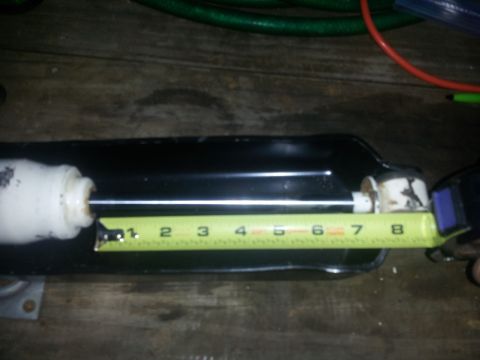 1988 Ford Bronco - A shock absorber is measured with a tape measure. The registry claims it is from a 1988 Ford Bronco, but this is unconfirmed.