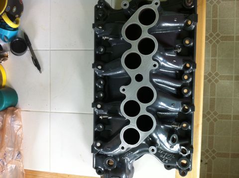 1992 Ford Bronco - Close-up of a black intake manifold, showing part numbers and port openings.