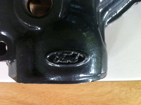 1992 Ford Bronco - A Ford emblem is visible on a dark, metallic engine part, possibly from a truck or SUV.