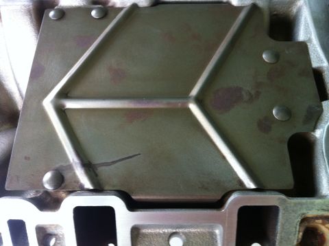 1992 Ford Bronco - Engine intake manifold part with a green metal cover plate, showing some discoloration.