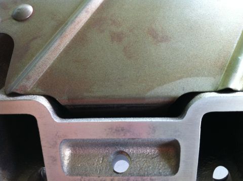 1992 Ford Bronco - This is a close-up view of a metallic engine component, showing its textured surface and fastening bolts.