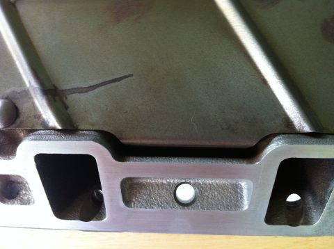 1992 Ford Bronco - Close-up view of an engine intake manifold, showing casting details and a dark stain.