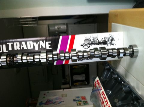 1992 Ford Bronco - A camshaft is shown with its packaging, which includes the Ultradyne logo and a graphic of a tractor.
