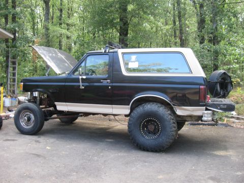 1990 Ford Bronco - This lifted 1990 Ford Bronco is shown with its hood open, revealing the engine bay.