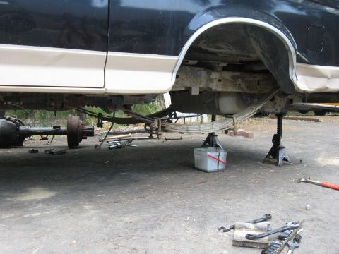 1990 Ford Bronco - Underside view of a 1990 Ford Bronco with its rear axle disassembled and supported by jack stands.