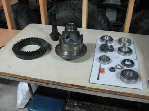 1990 Ford Bronco - Differential and associated parts are arranged on a table, ready for installation.