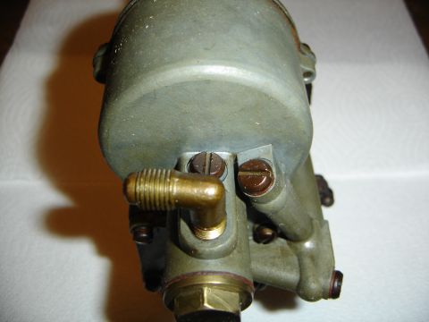 1996 Ford Bronco - A close-up view of a carburetor part, showing its metallic components and fasteners.