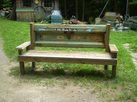 1979 Ford Bronco - This bench incorporates a vintage Ford tailgate as its backrest, set in a grassy outdoor area.