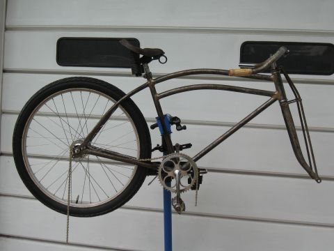 1994 Ford Bronco - A bicycle frame is mounted on a repair stand against a white garage door.