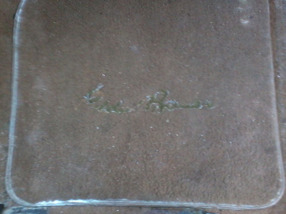 Clear plastic part with embossed cursive text that reads 'Eddie Bauer'