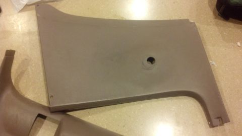 1995 Ford Bronco - A tan interior door panel, likely from a vehicle, is shown with a circular cutout for a speaker or other component.
