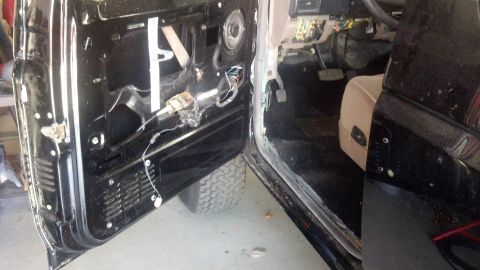 1995 Ford Bronco - The interior of a vehicle is shown with the driver's side door panel removed for access to internal components.