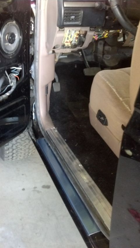 1995 Ford Bronco - The interior of a vehicle is shown with the driver's side door open, revealing the dashboard and seat.