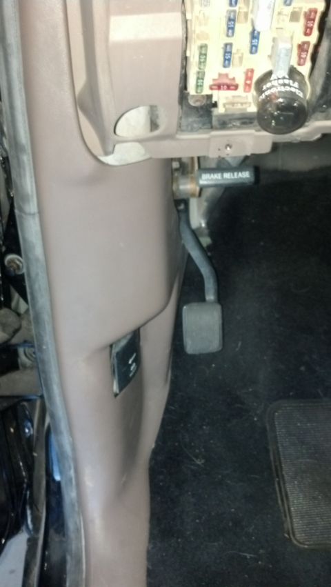 1995 Ford Bronco - The interior of a 1995 Ford Bronco shows the driver's side footwell, including the brake pedal and fuse box.