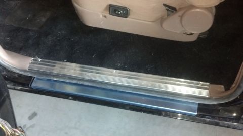 1995 Ford Bronco - Close-up of a vehicle's interior door sill and seat controls.