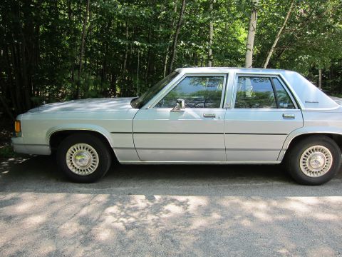 1991 Ford LTD Crown Victoria - Side profile of a silver 1991 Ford Crown Victoria LTD sedan parked outdoors.