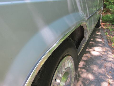 1991 Ford LTD Crown Victoria - The chrome trim around the wheel well is a prominent feature of this vehicle's side profile.