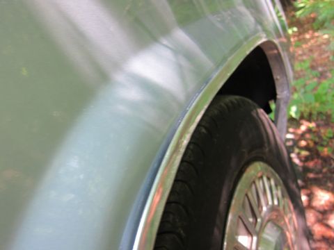 1991 Ford LTD Crown Victoria - Close-up of the fender and tire of a light blue 1991 Ford Crown Victoria LTD, seen from the side.