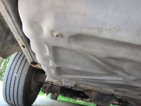 1991 Ford LTD Crown Victoria - Underside view of a vehicle, focusing on the fuel tank and suspension system.