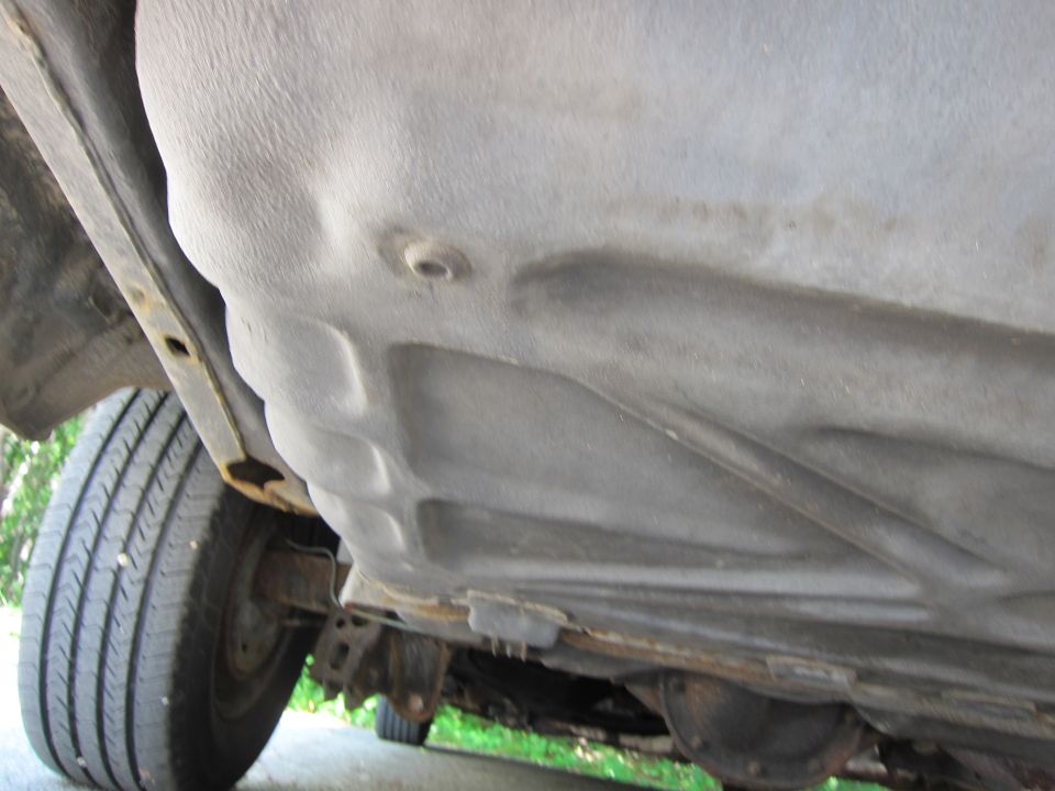 Underside view of a vehicle showing the fuel tank and suspension components