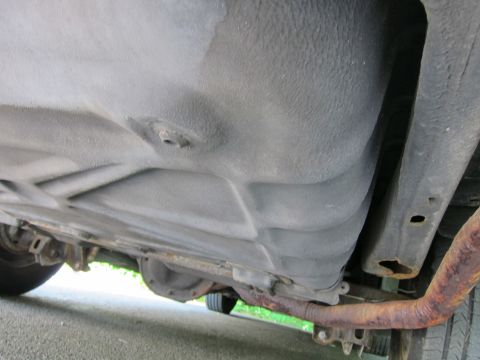 1991 Ford LTD Crown Victoria - Underside view of a car, focusing on the fuel tank and exhaust system components.