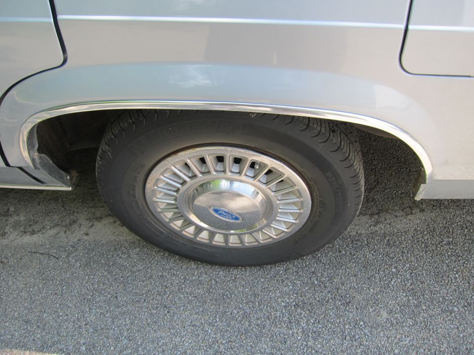 Silver sedan rear wheel with Ford hubcap