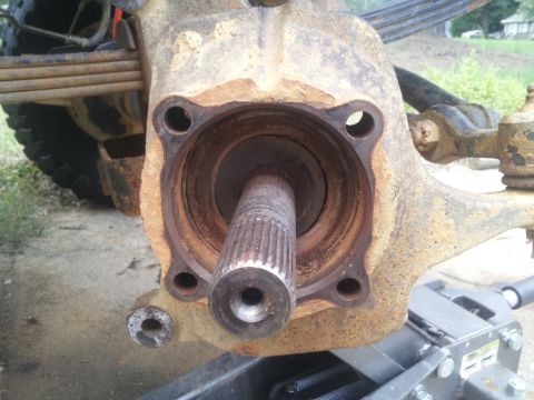 1988 Ford Bronco - Close-up of a heavily rusted wheel hub assembly and axle shaft.