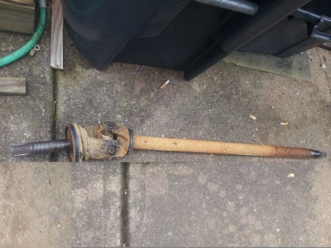 1988 Ford Bronco - A single driveshaft rests on a concrete surface, showing signs of wear and rust.