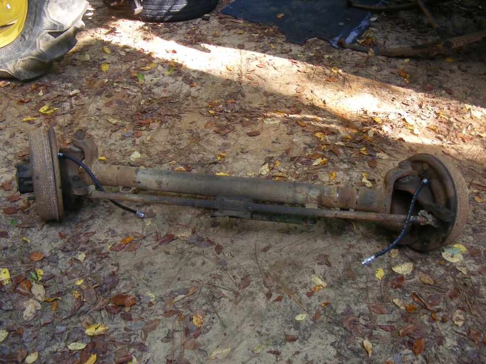 Rear axle assembly with drum brakes and brake lines on the ground