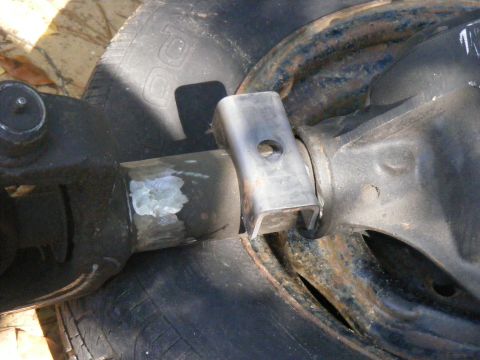 1978 Ford Bronco - Detail of a vehicle's rear axle assembly, showing a welded bracket and part of a tire.