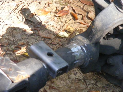 1978 Ford Bronco - Vehicle suspension part and hitch receiver shown outdoors on the ground.