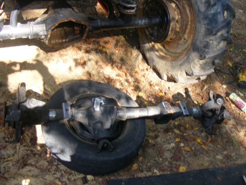 1978 Ford Bronco - Close-up of vehicle axles and tires, possibly during a repair or modification.