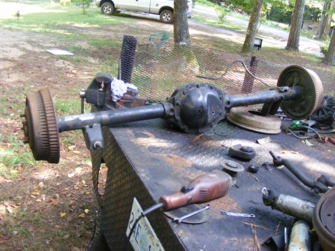 1978 Ford Bronco - A rear axle assembly is clamped in a vise on a workbench, with tools scattered around.