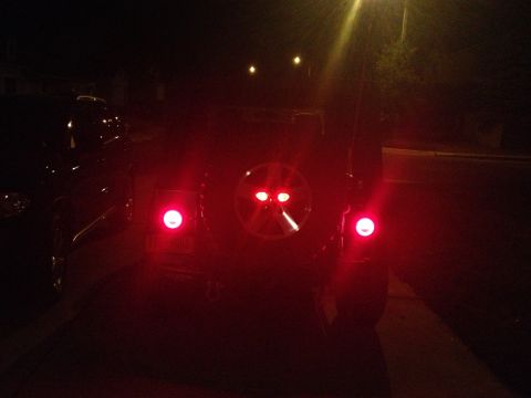2005 Jeep Wrangler - Rear view of a 2005 Jeep Wrangler at night with brake lights on.